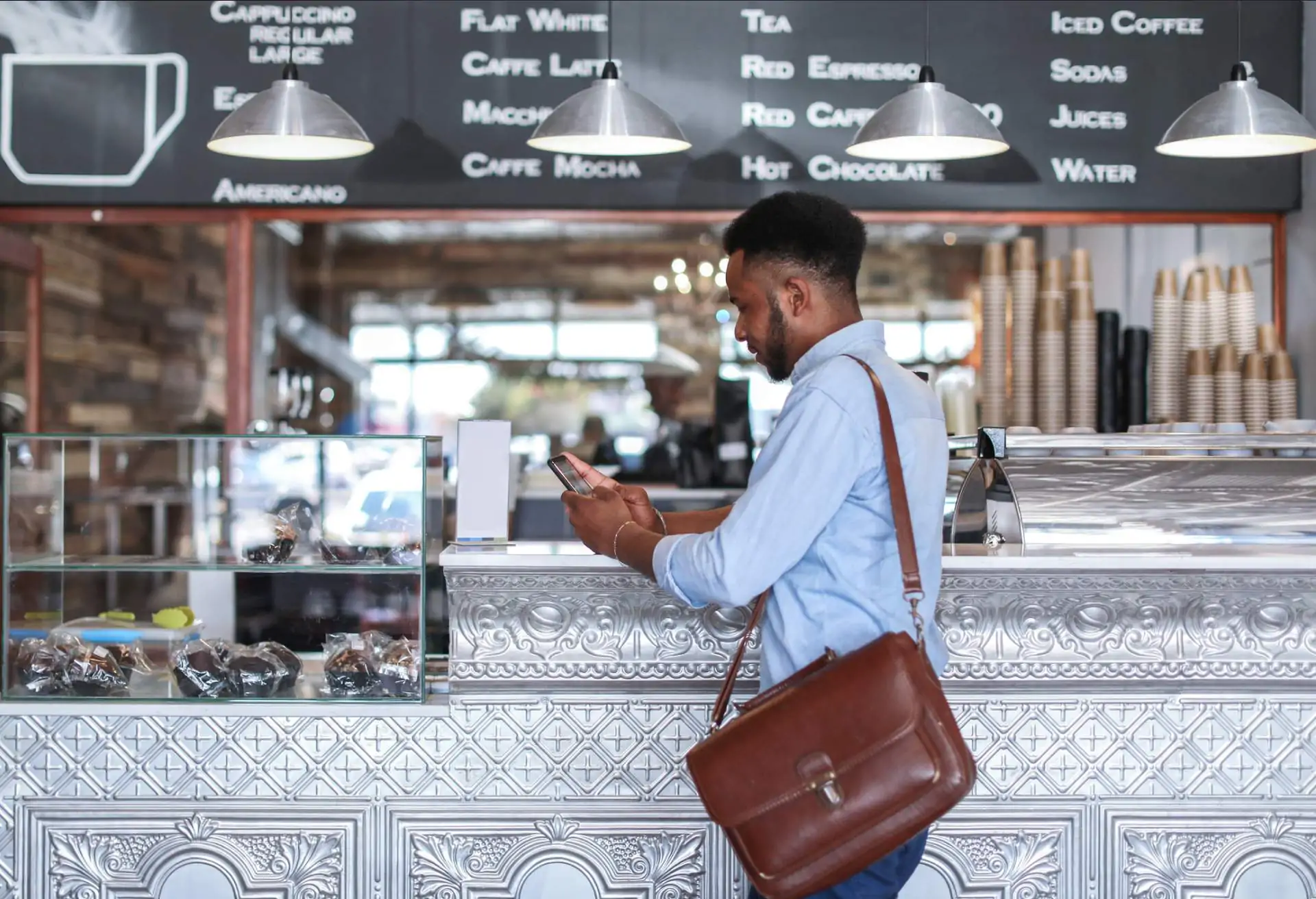 Restaurant goer ordering food at a counter with a phone