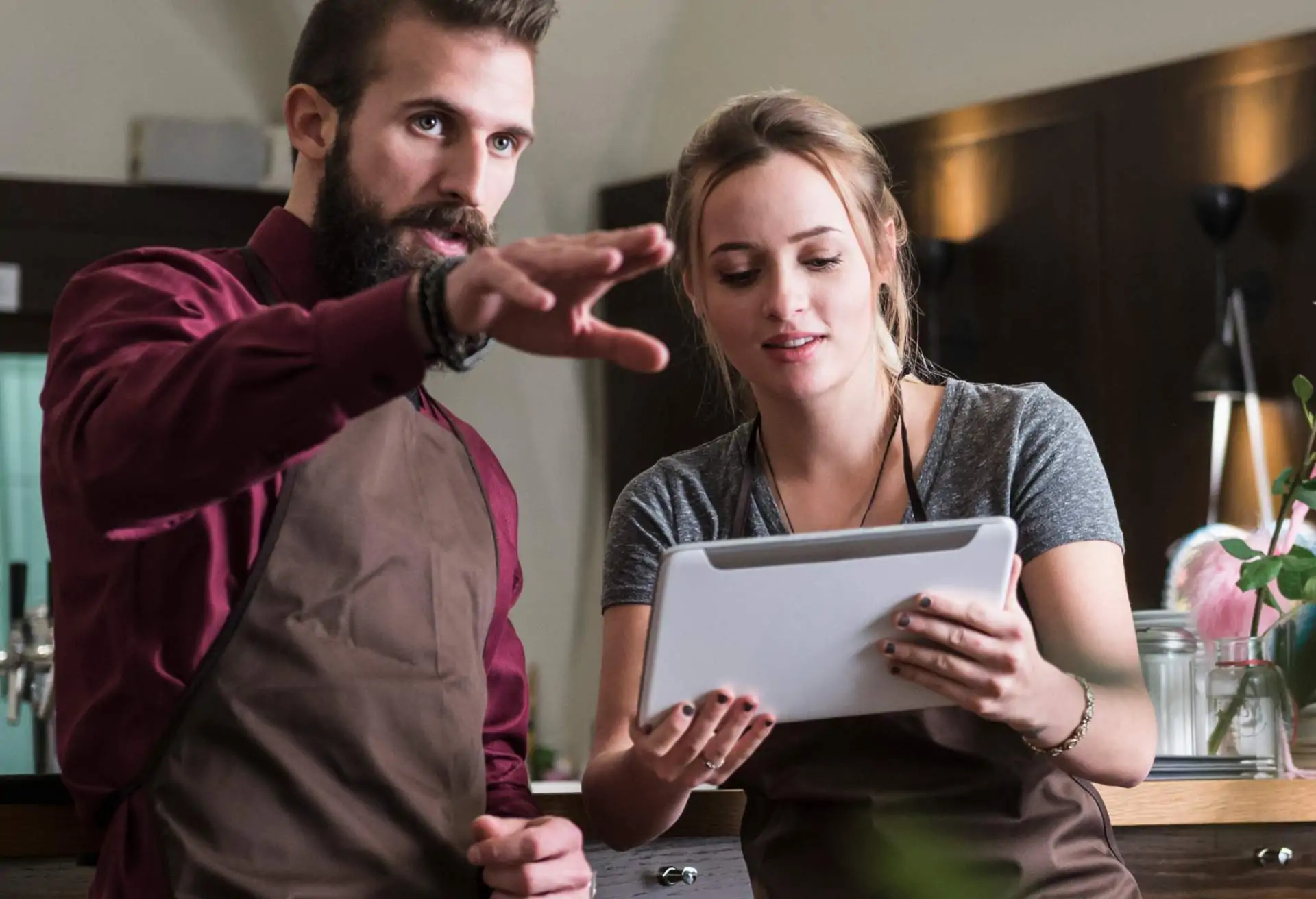 Restaurant team members plan the upcoming shift holding a tablet computer