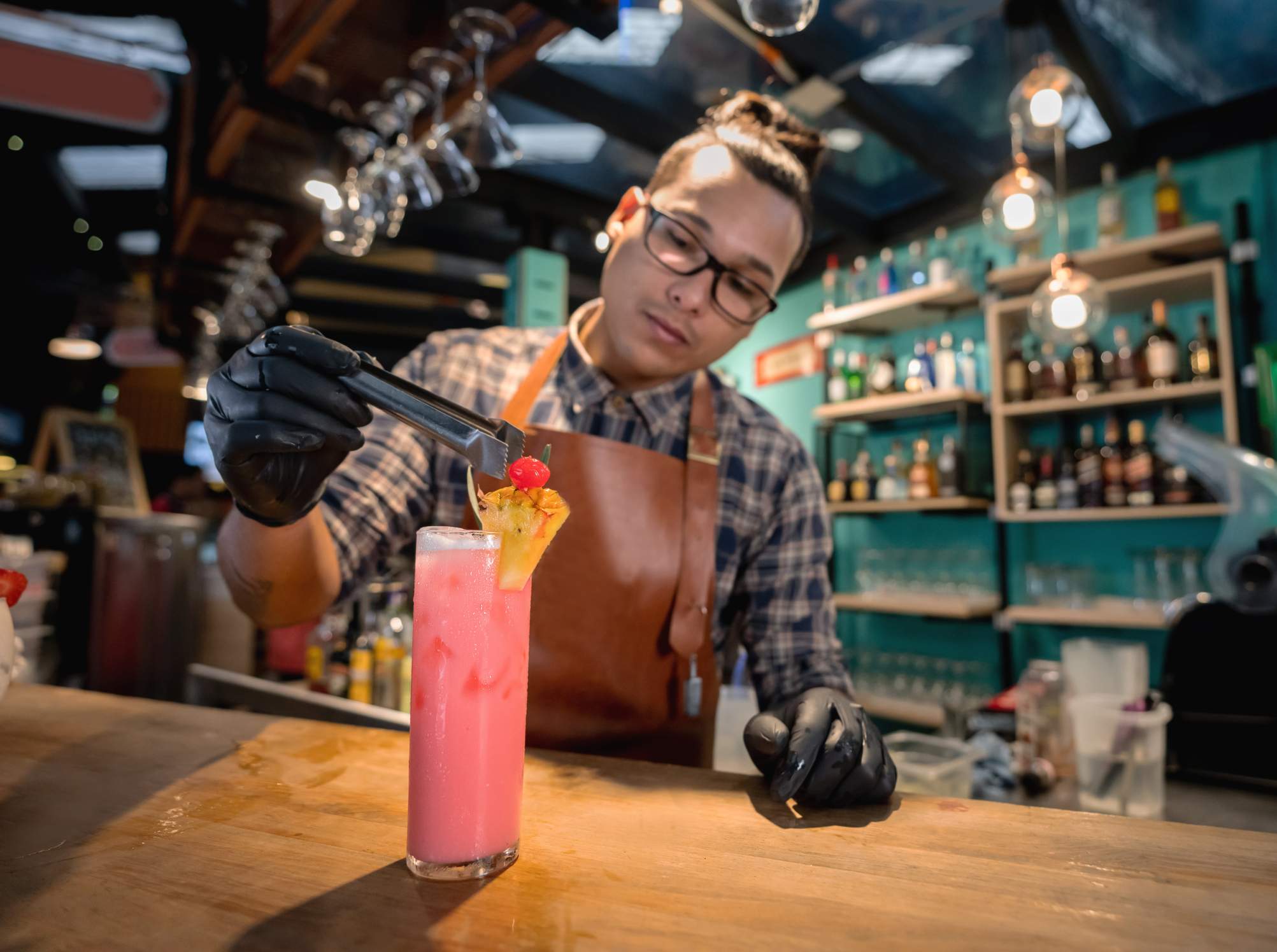 Image depicts a bartender making a mocktail.