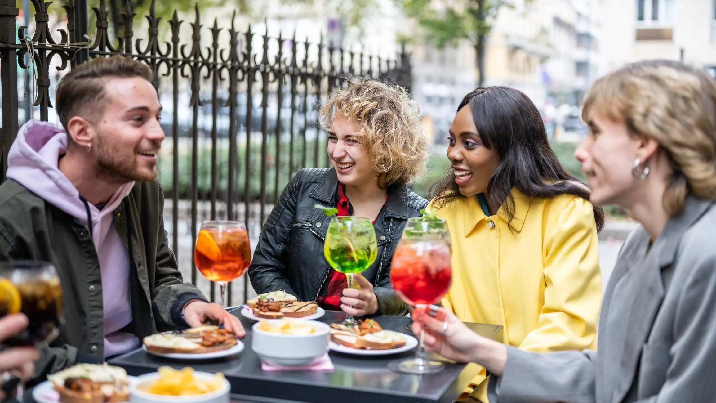 Image depicts a group of people dining at an outdoor restaurant, drinking non-alcoholic beverages.