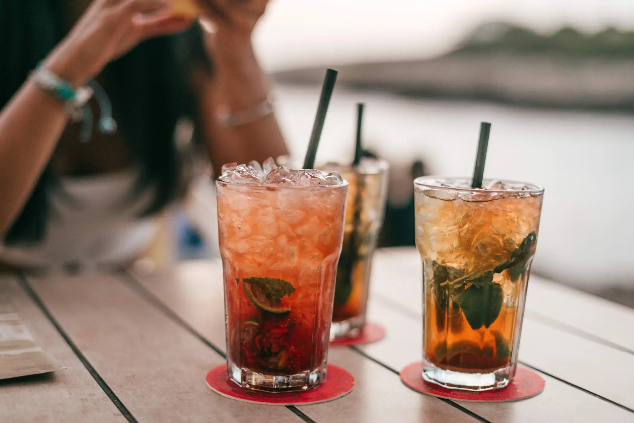 Image depicts three mojito mocktails sitting on a table.