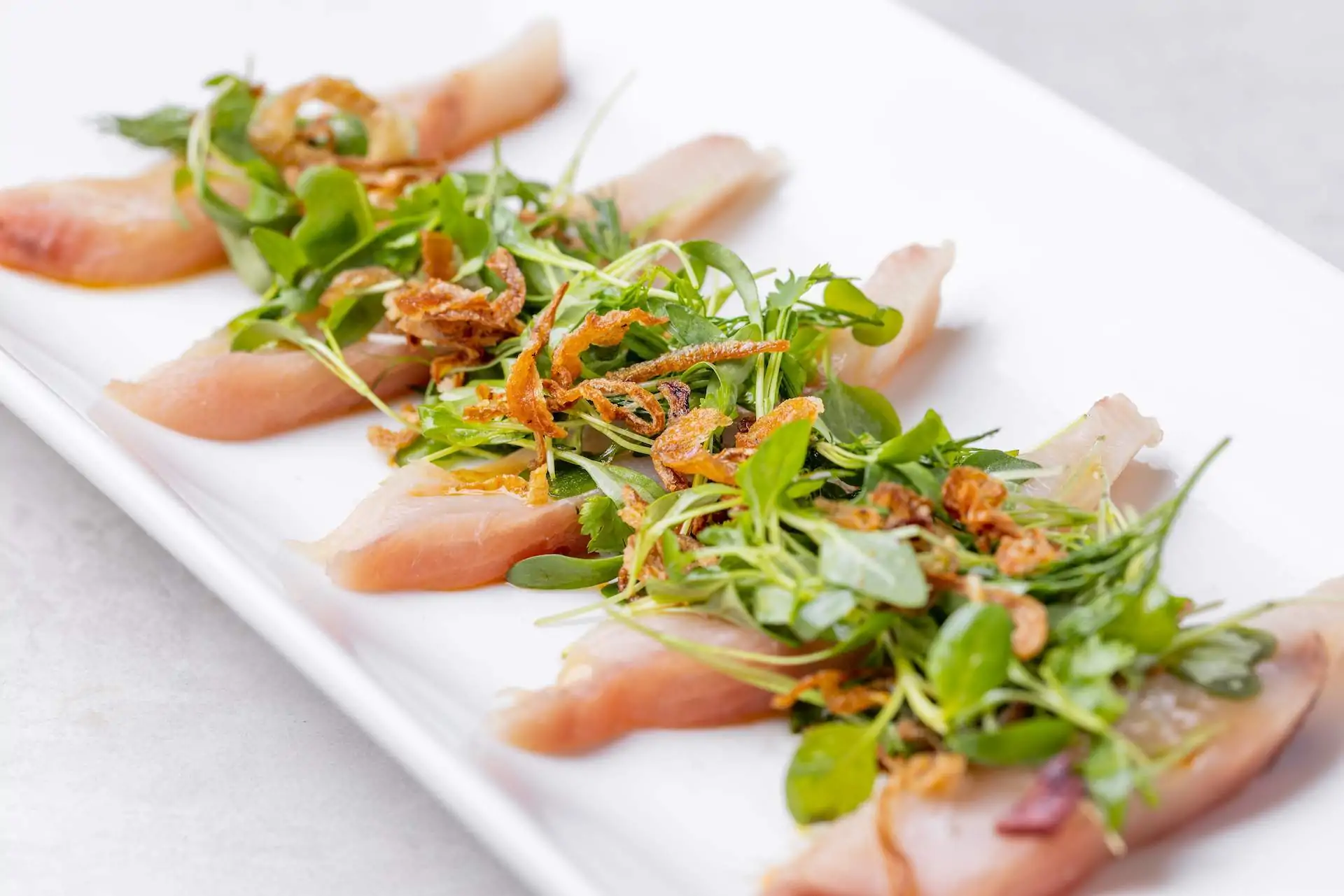 A plate of raw seafood with salad at Savida