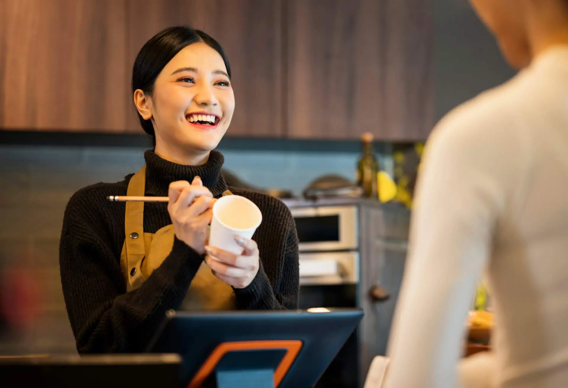 A young restaurant worker helps a customer