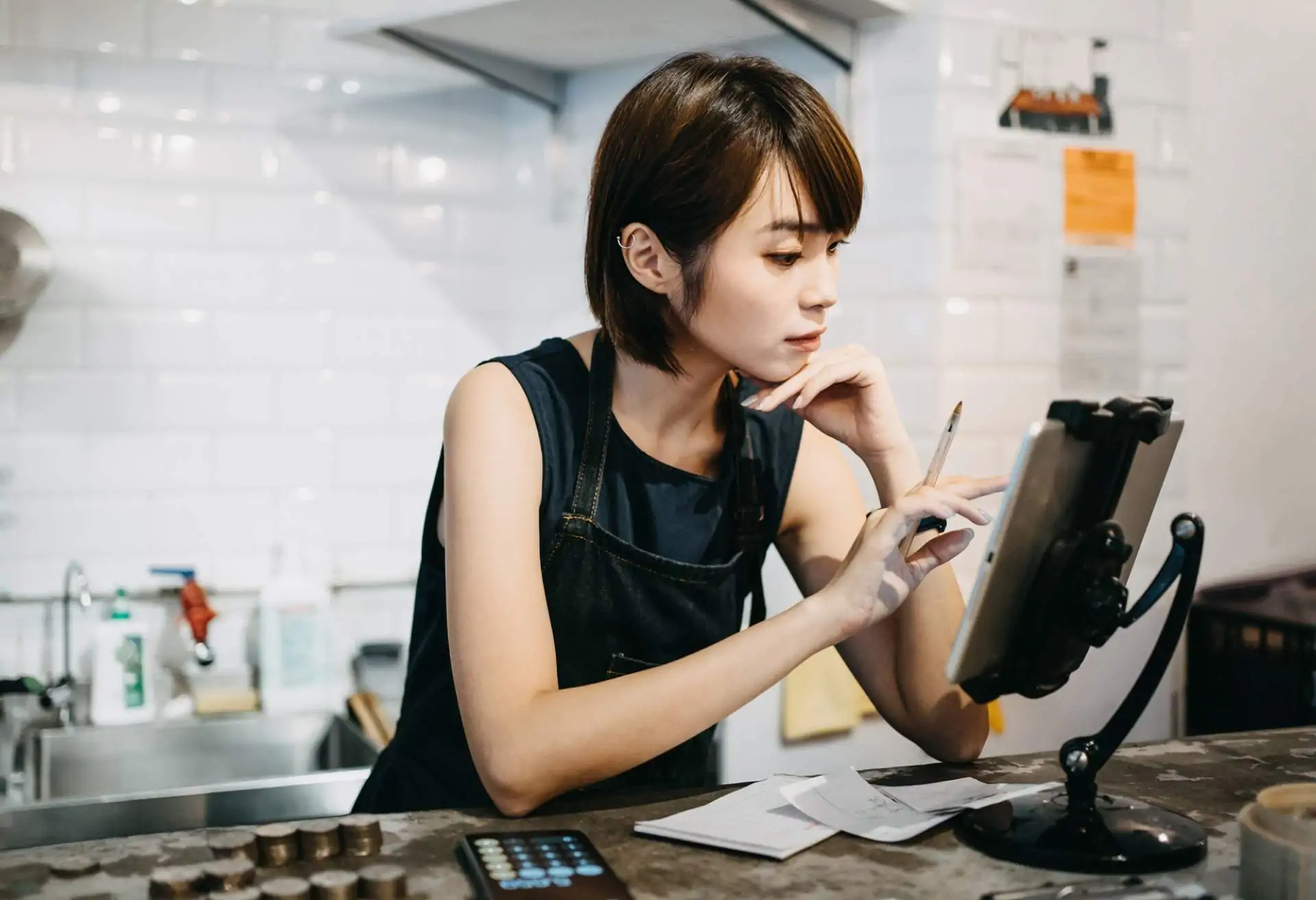 A restaurant worker concentrates while working on a tablet computer