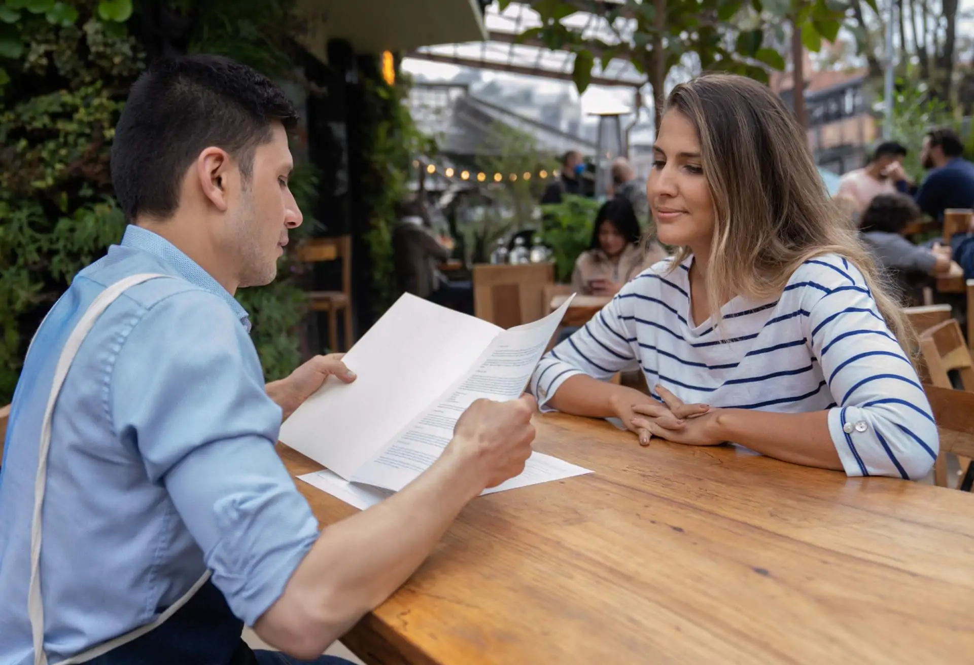 A manager reviews a resume and interviews a candidate for a restaurant job