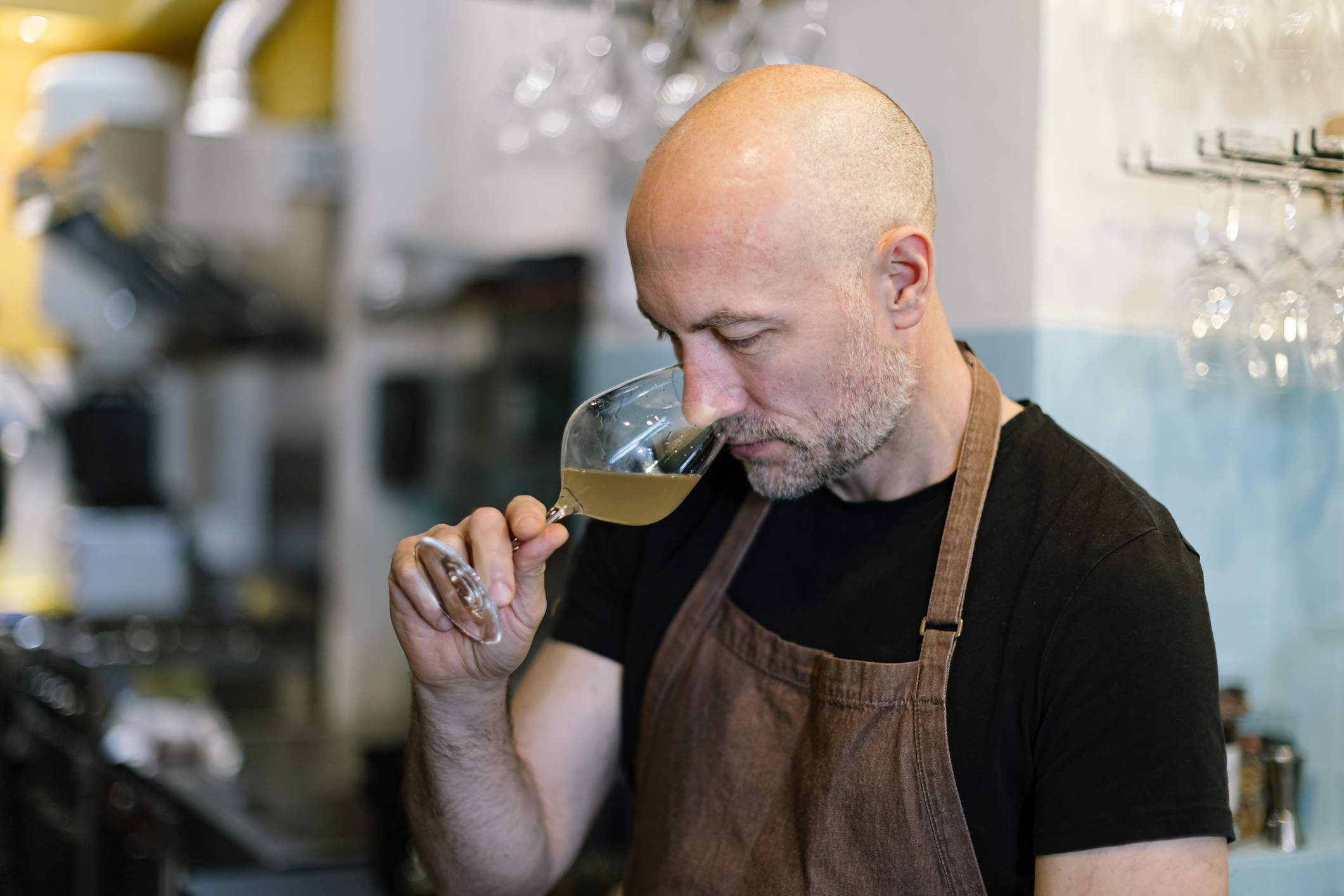 Image depicts a sommelier smelling wine.