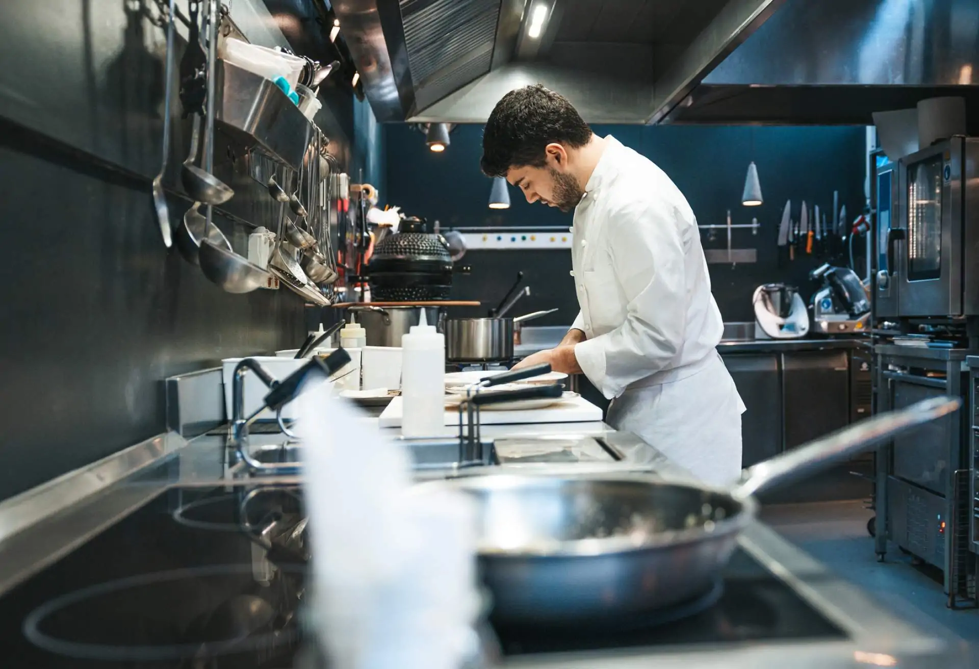 Chef cooking in a kitchen with a sleek induction cooktop