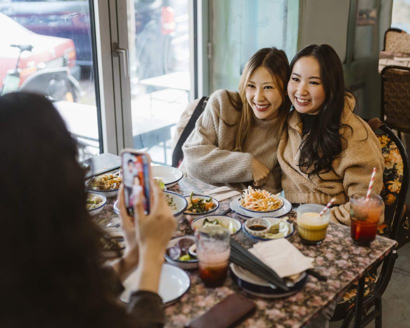 Social media influencers taking selfies at a restaurant