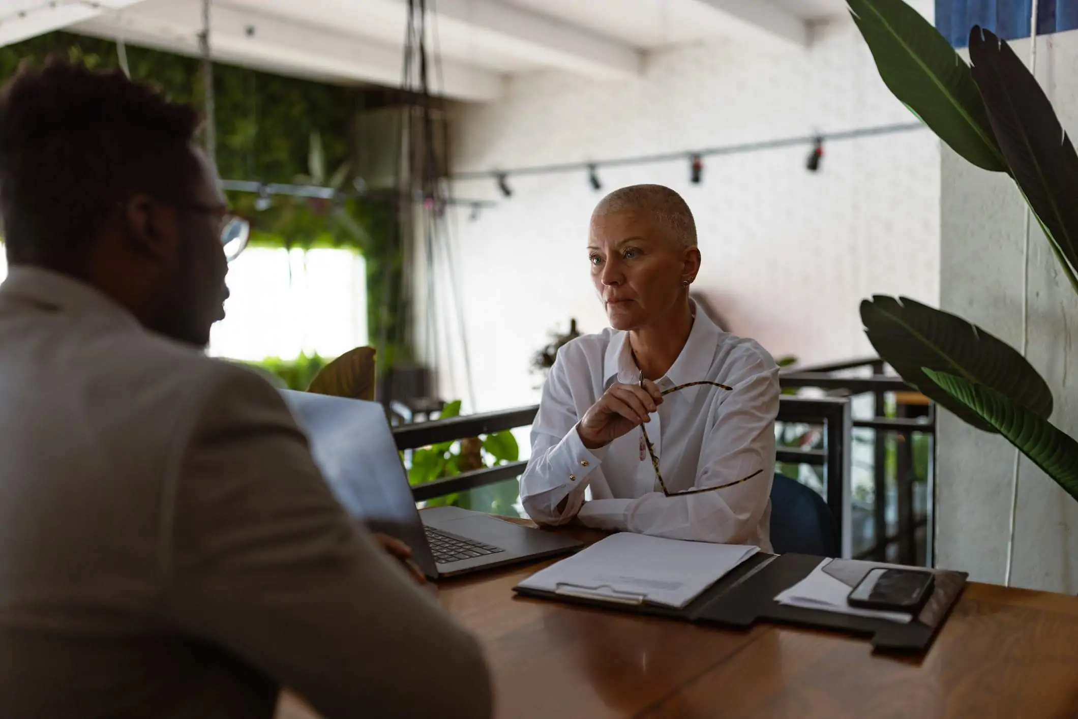 Image depicts a person conducting an interview with another person inside of a restaurant.