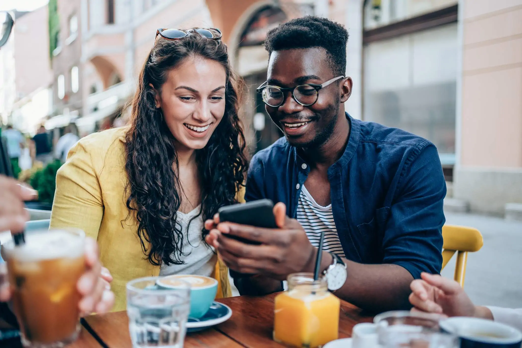 Image depicts two diners looking at a phone.