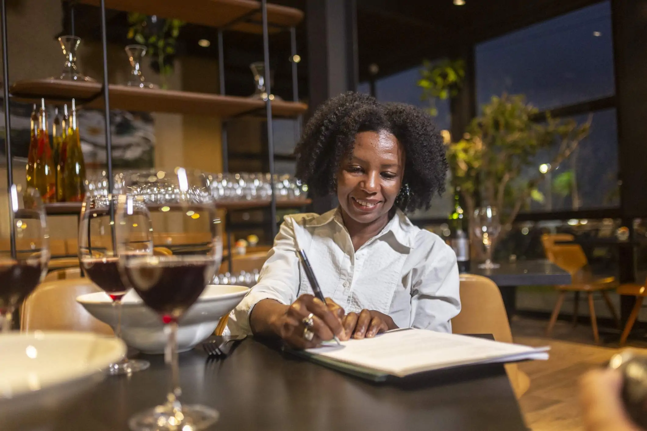 A restaurant owner crafts a restaurant marketing plan in her restaurant after hours