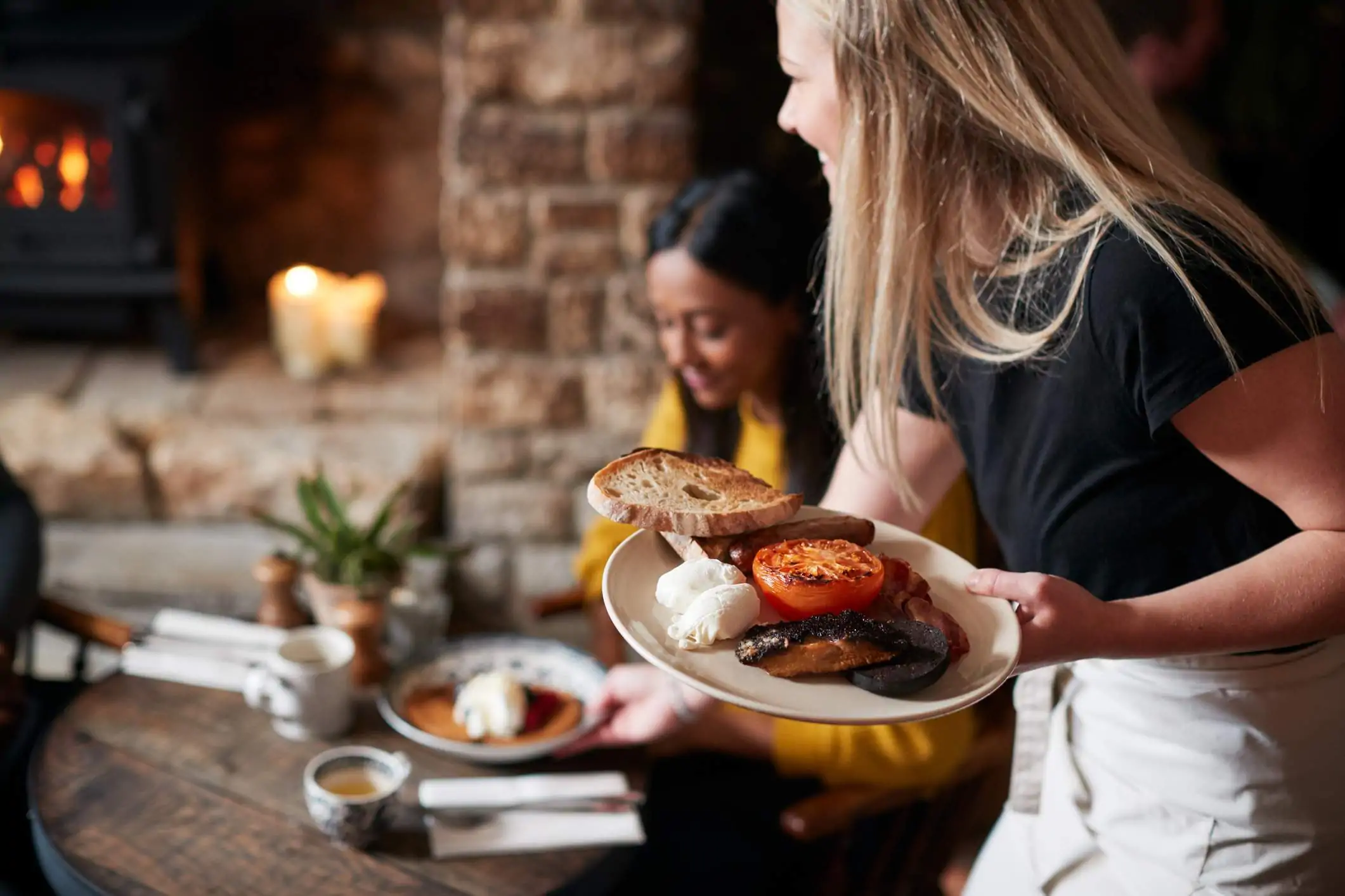 Image depicts a server bringing a table their food.