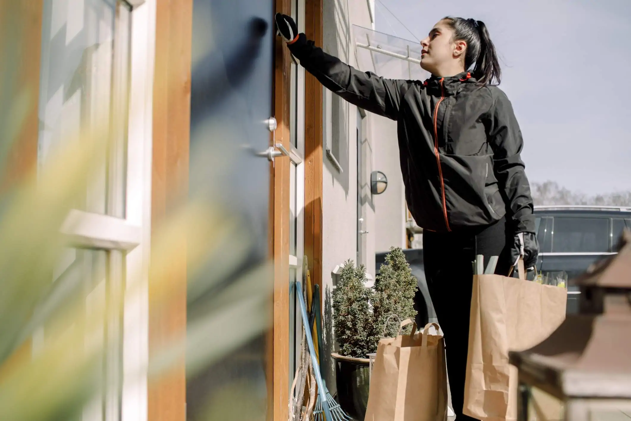 Image depicts a delivery driver knocking on a door.