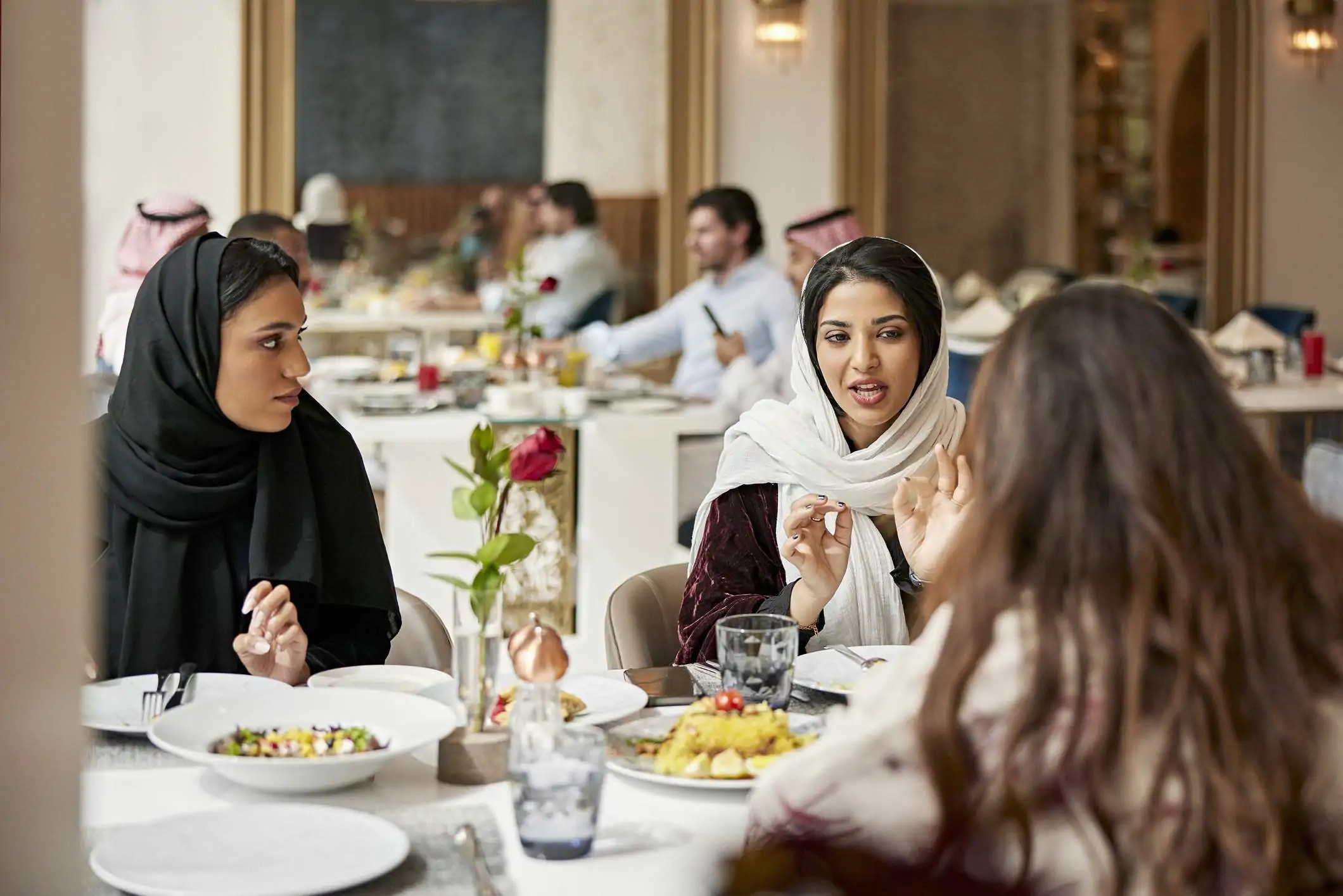 Image depicts a group of people dining at a restaurant.