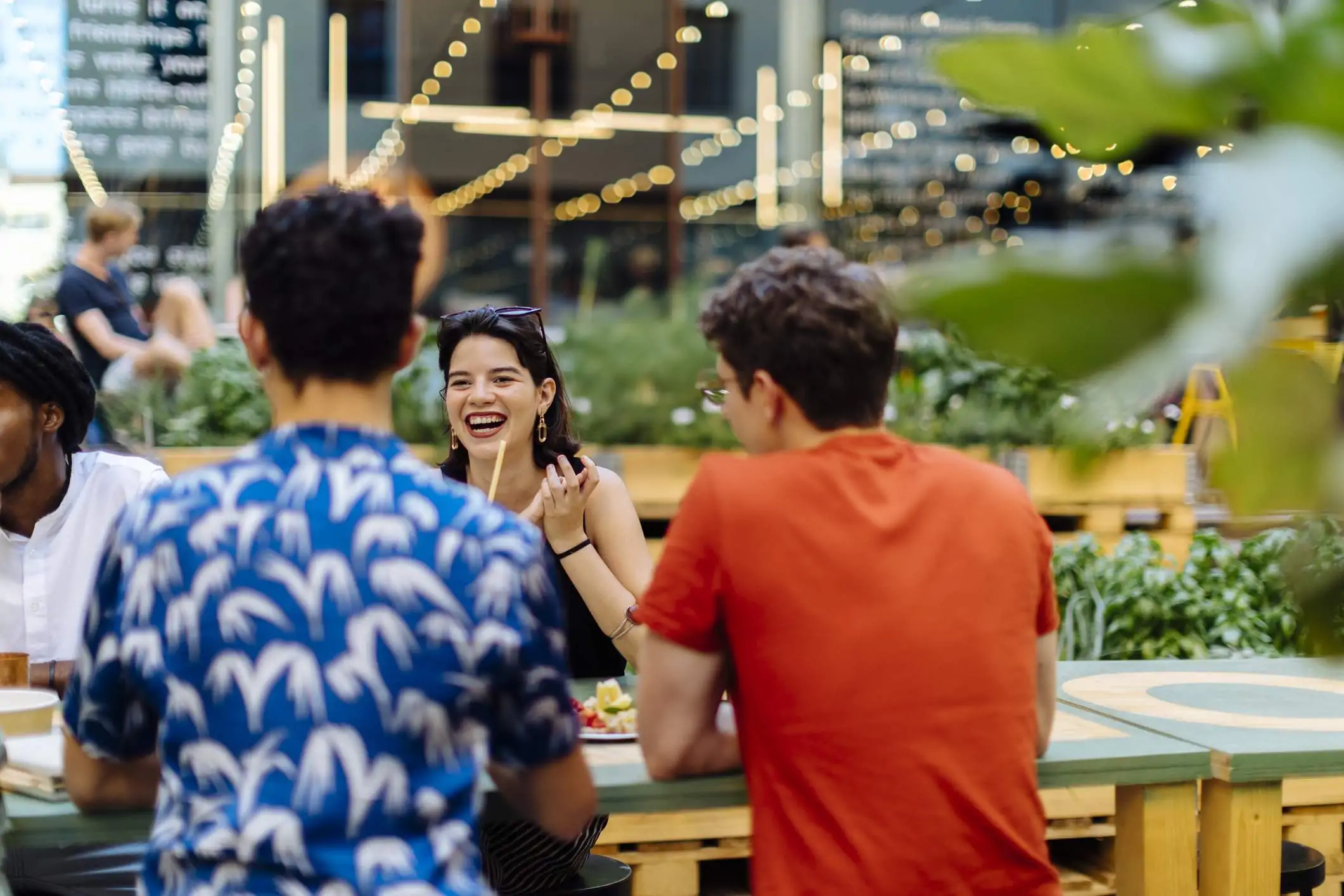 Image depicts a group of people dining at a restaurant.