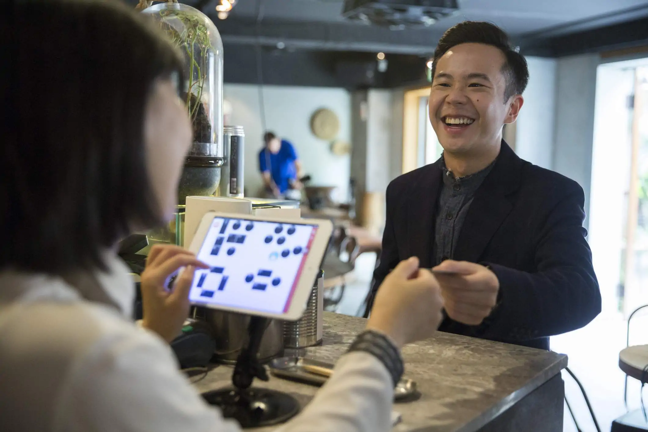 Image depicts a guest giving payment to a restaurant worker.