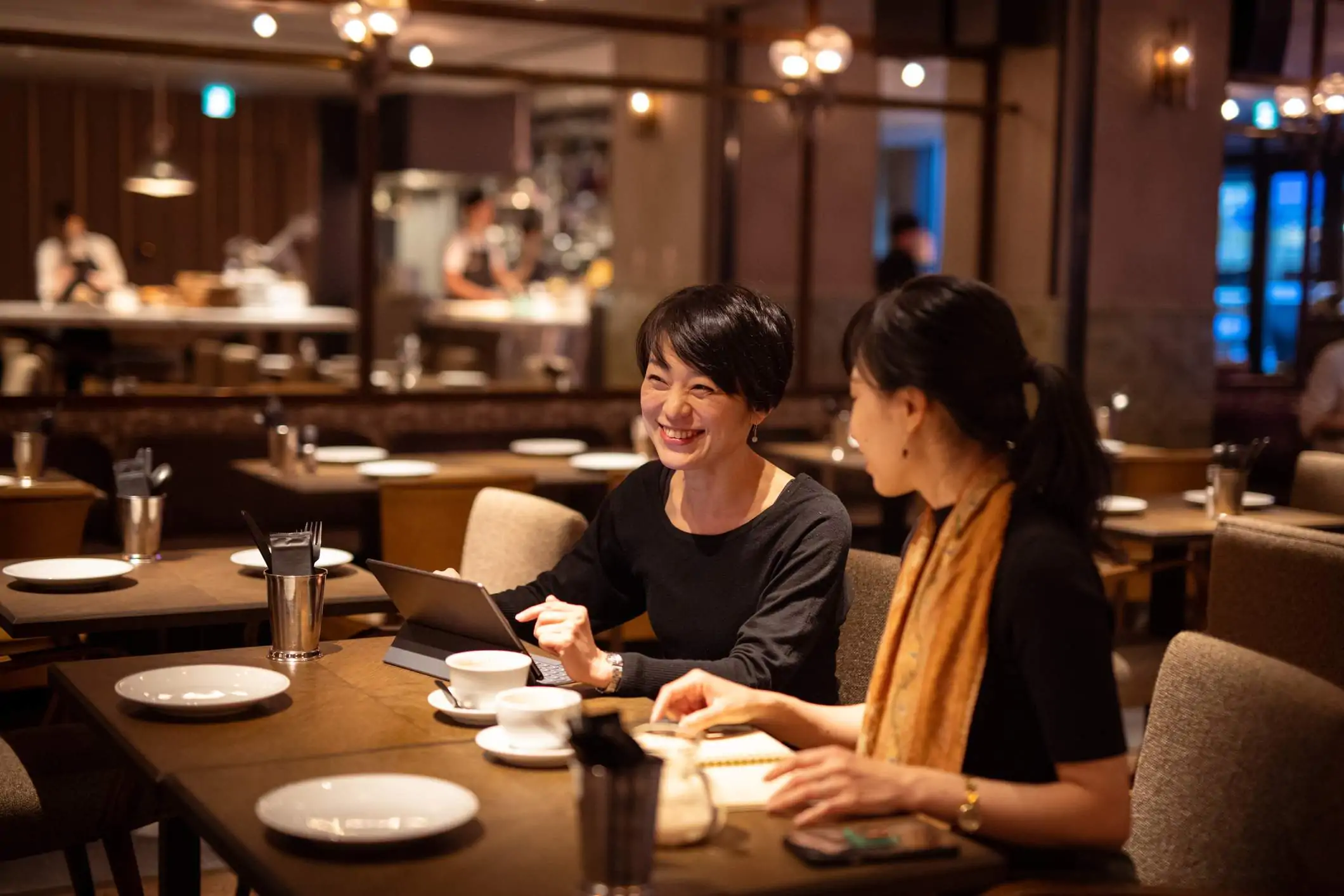 Image depicts two restaurant workers using a tablet.