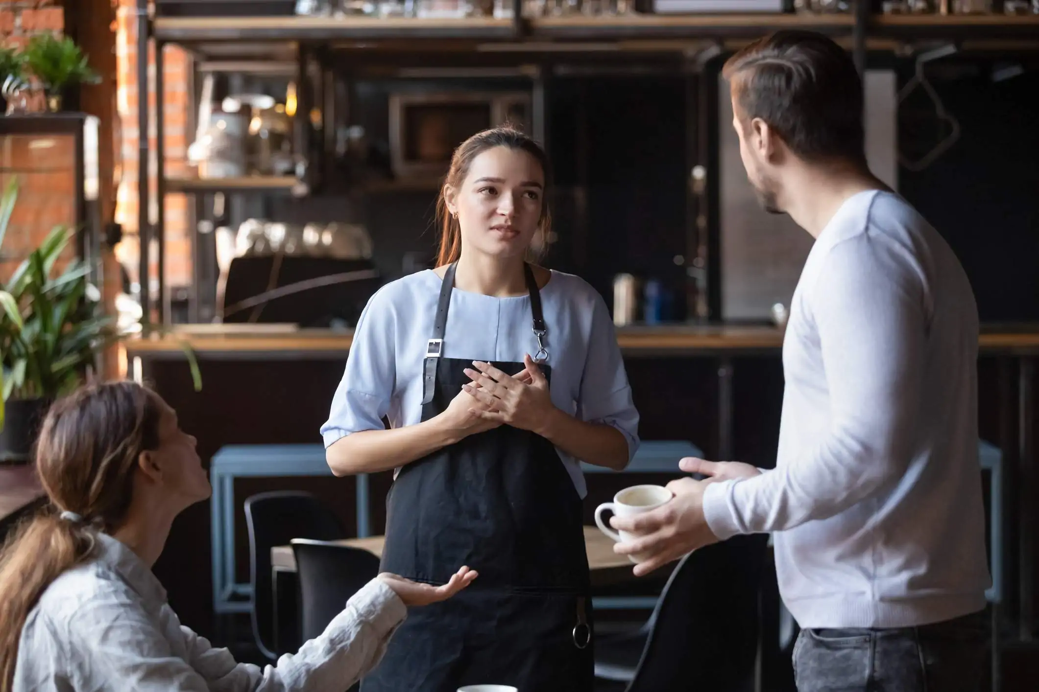 Image depicts a service worker talking to two guests