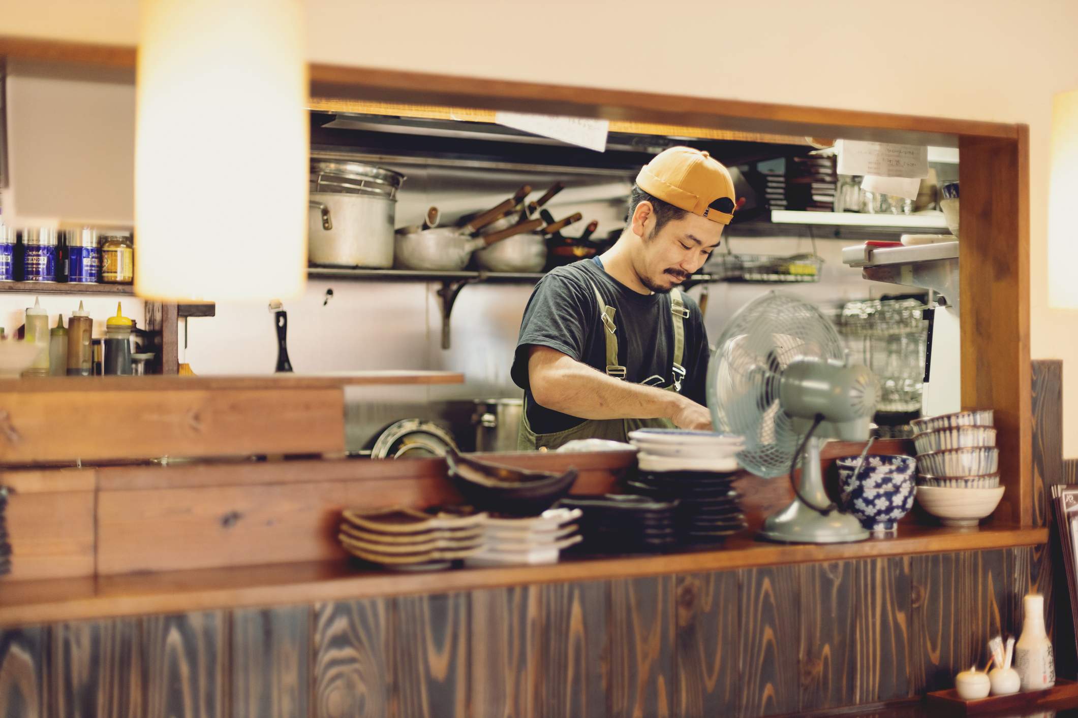 Image depicts a restaurant worker behind the counter.