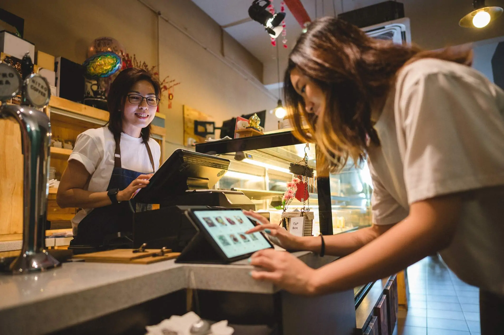 Image depicts a guest using a tablet to select an order.